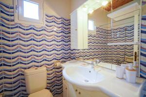 Un baño con lavabo, inodoro y espejo. en Makyneia Garden House, en Manglaraíika 24 fotos más