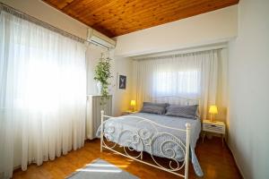 Un dormitorio con una cama blanca y una ventana. en Makyneia Garden House, en Manglaraíika