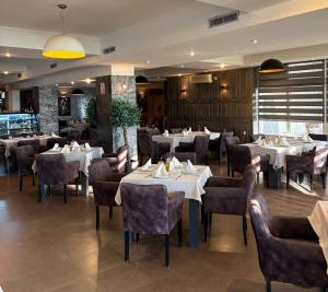 a restaurant with tables and chairs in a room at Hotel Europa 92 in Ferizaj