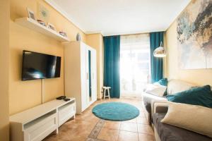 a living room with a couch and a flat screen tv at Apartamento Benimar III in Cala de Finestrat