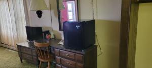 a desk with a television on top of a dresser at Amaris Inn in Redfield