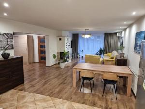 a kitchen and living room with a wooden table and chairs at Orzechowy Dom in Trzebnica