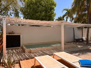 a backyard with a swimming pool under an umbrella at Casa AMI in El Cuyo
