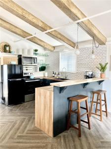 a kitchen with black appliances and wooden stools at Bluebird Day - Fox Den South in Bend
