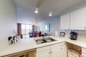 Una cocina con fregadero y una sala de estar. en Buena Vista 601, en Gulf Shores