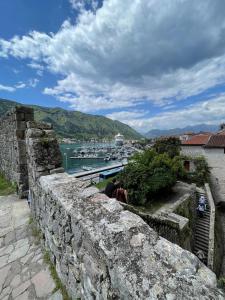 a group of people sitting on a wall looking over the water at Kotor Old Town Cozy Escape in Kotor +10 photos