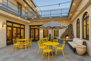 a patio with yellow tables and chairs and a fireplace at The Live Hotel in Los Angeles