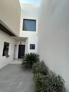 un corridoio di un edificio bianco con piante di Beautiful residence 10 minutes from the consulate! a San Lorenzo