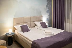 Un dormitorio con una cama grande con almohadas moradas. en HerMira House, en Sibiu