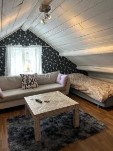a living room with a couch and a coffee table at 18th century cottage with private beach in Torsö
