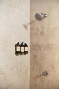eine Dusche mit vier Flaschen an einer Wand in der Unterkunft Casa Lumaya in Brisas de Zicatela