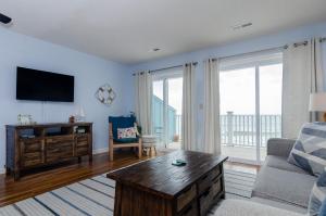 a living room with a couch and a tv at Rudicile by Bryant Real Estate in Kure Beach