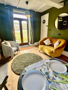 a living room with a table and a couch at Wicket Green Cottage Hayfield in Hayfield +31 photos
