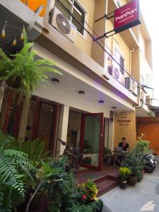 a man sitting in a chair in front of a building at PanPan Hostel in Bangkok