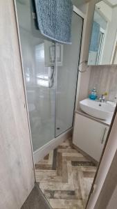 a bathroom with a shower and a sink at Stunning 2 bed Luxury Caravan at Hoburne Devon Bay, with Hot Tub and sea view in Paignton +10 photos