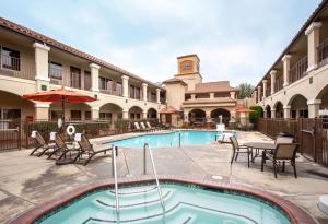a pool at a hotel with chairs and a table at Ayres Hotel Redlands - Loma Linda in Redlands