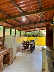 a patio with a table and chairs and a refrigerator at Casa de férias em trindade paraty in Paraty
