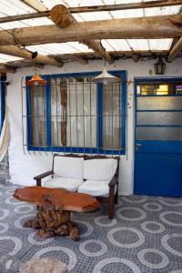 een kamer met een bank, een tafel en een blauwe deur bij Casita Meraki para 2 personas in Villa Carlos Paz