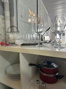 a kitchen counter with wine glasses and plates on it at Pousada Refúgio Encantado in Goiás