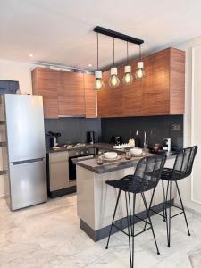 cocina con nevera y barra con sillas en Central Maarif Studio, en Casablanca