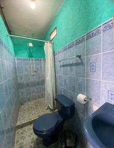 Un baño con un inodoro azul y un lavabo. en Hotel y Restaurante Pinocchio, en San Pedro La Laguna 63 fotos más