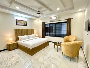a bedroom with a bed and a chair and a window at Comfort & Luxury Stay In Islamabad in Islamabad