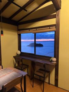 a room with a desk and a large window at IZU Elysian View in Koura