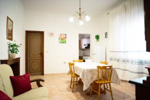 a dining room with a table and chairs and a kitchen at Casa L'Iris in Villasimius