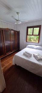 a bedroom with a white bed and a window at Casa da vó in Morretes +3 photos