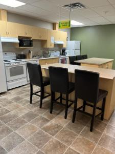a large kitchen with a table and chairs in it at Riverview Suites in Clarenville +10 photos