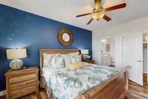 a bedroom with a bed and a ceiling fan at Point West Resort in Galveston +17 photos
