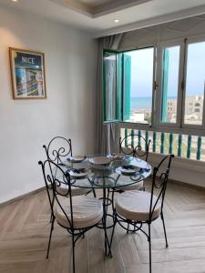 une salle à manger avec une table en verre et quatre chaises dans l'établissement Suite d'Hôtel vue sur mer, à Yasmine