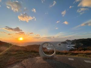 a mirror on the side of a road with the sunset at IZU Elysian View in Koura