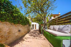 a bench sitting next to a wall with a tree at Stylish home - comfortable holidays near the beach. in Panormos Rethymno