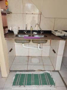 a kitchen with a sink and a tiled floor at Casa individual 01 in Primavera do Leste +5 photos