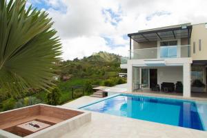 a villa with a swimming pool in front of a house at Casa de Campo Monblack in El Peñol