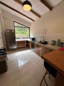 a large kitchen with a large window and a sink at Q'inti Apartment in Lamay