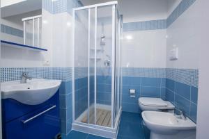 a blue tiled bathroom with a shower and a toilet at CASA Annmarie in Castellammare del Golfo +27 photos