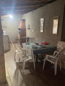 a dining room with a table and chairs and a fireplace at recanto Gonzales in Sarapuí