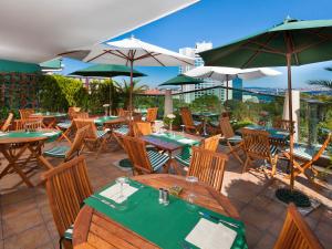 a restaurant with wooden tables and chairs and umbrellas at Germir Palas Hotel - Special Class in Istanbul