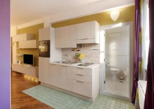 een witte keuken met een wastafel en een toilet bij Central Apartment in Salerno