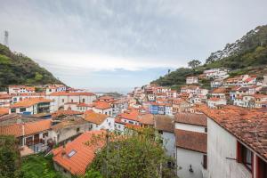 un pueblo en una colina con casas y tejados en Charming Seaside Escape in Picturesque Cudillero, en Cudillero