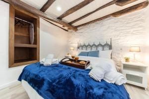 Un dormitorio con una cama grande con sábanas azules. en Charming Seaside Escape in Picturesque Cudillero, en Cudillero