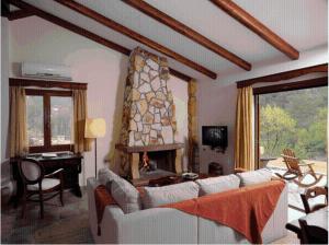 a living room with a couch and a fireplace at Apolithomeno Dasos Holiday Villas near Alexandroupolis in Lefkimmi