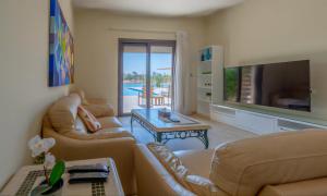 a living room with two couches and a television at Staylish Villas in Joubal Lagoon El Gouna in Hurghada