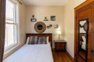 a bedroom with a white bed and a window at Chi-Town Hideout #2 in Berwyn