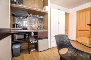 a kitchen with a table and a chair in a room at Willa Góry A - Noclegi z widokiem na góry śniadaniami i sauna in Bukowina Tatrzańska