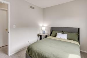 a bedroom with a bed and a table with a lamp at 3 Mi to Dtwn Royal Oak Getaway with Fenced Yard! in Hazel Park