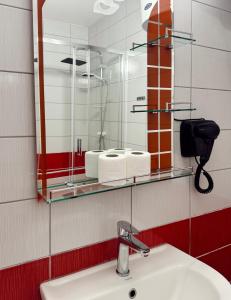 a bathroom with a sink and a mirror at Nook 95 Rooms in Prizren