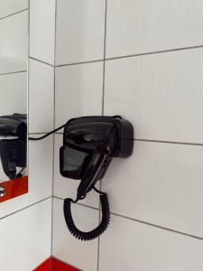 a black phone is hanging on a wall at Nook 95 Rooms in Prizren